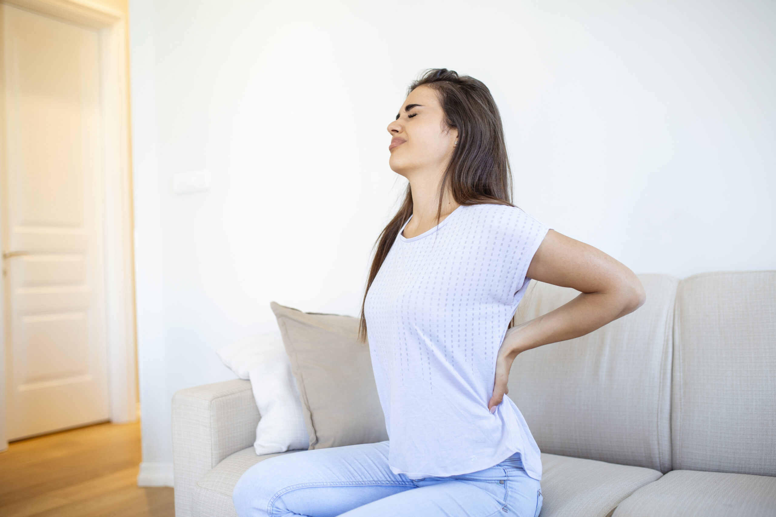 Success Stories 1 woman suffering from backache home lower back pain woman feels back pain massaging aching muscles sad woman suffers from lowback scaled